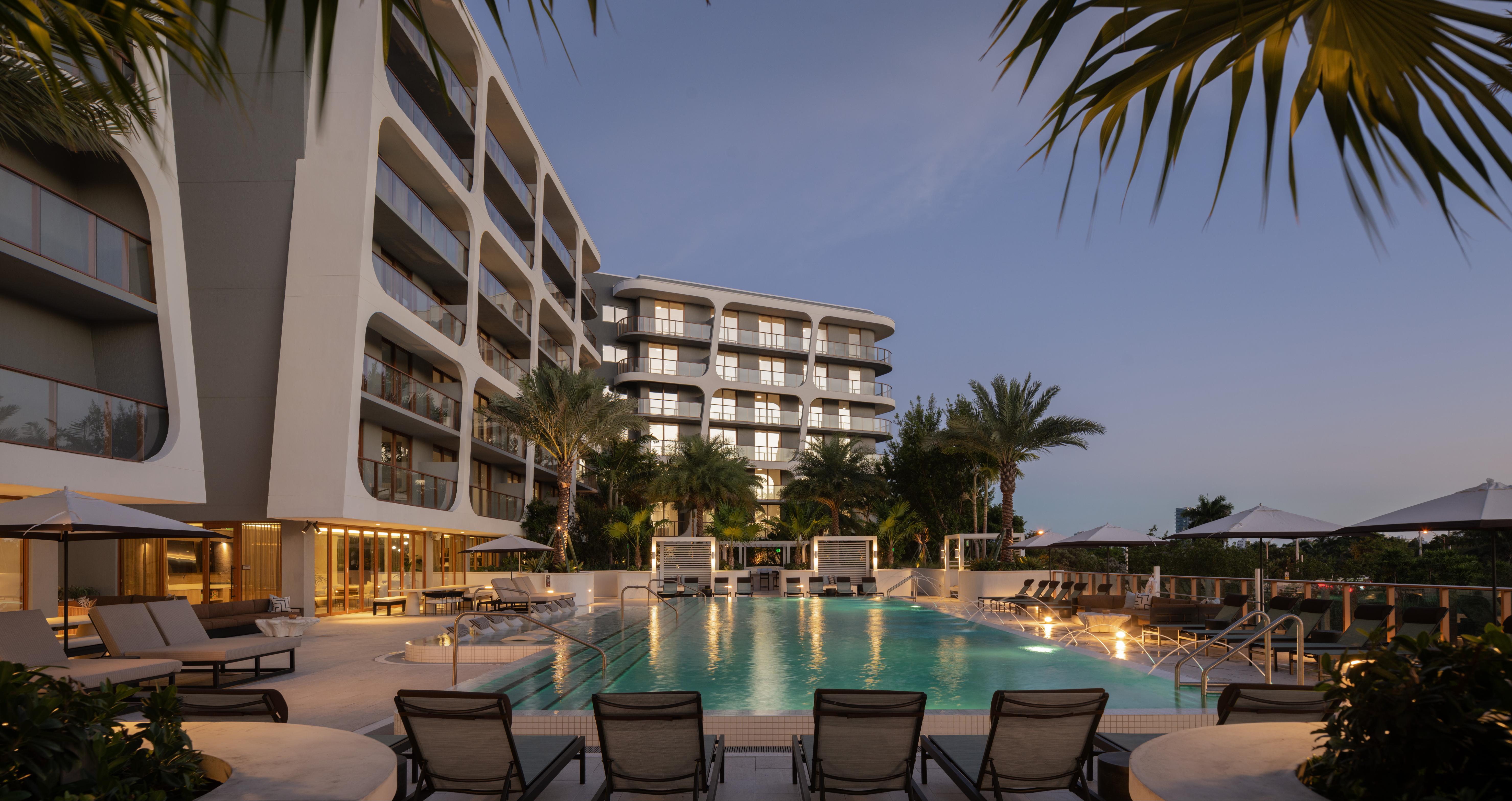 Avara elevated pool deck with lounge chairs and cabanas with view of Miami